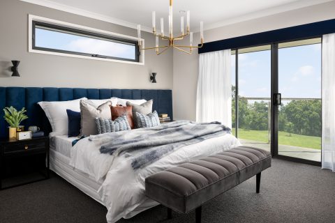 A bedroom with light coming through aluminium sliding doors