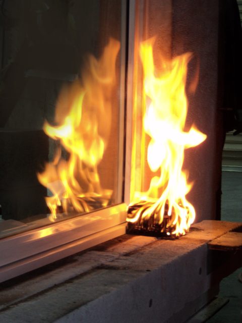 a flaming ball adjacent to a window